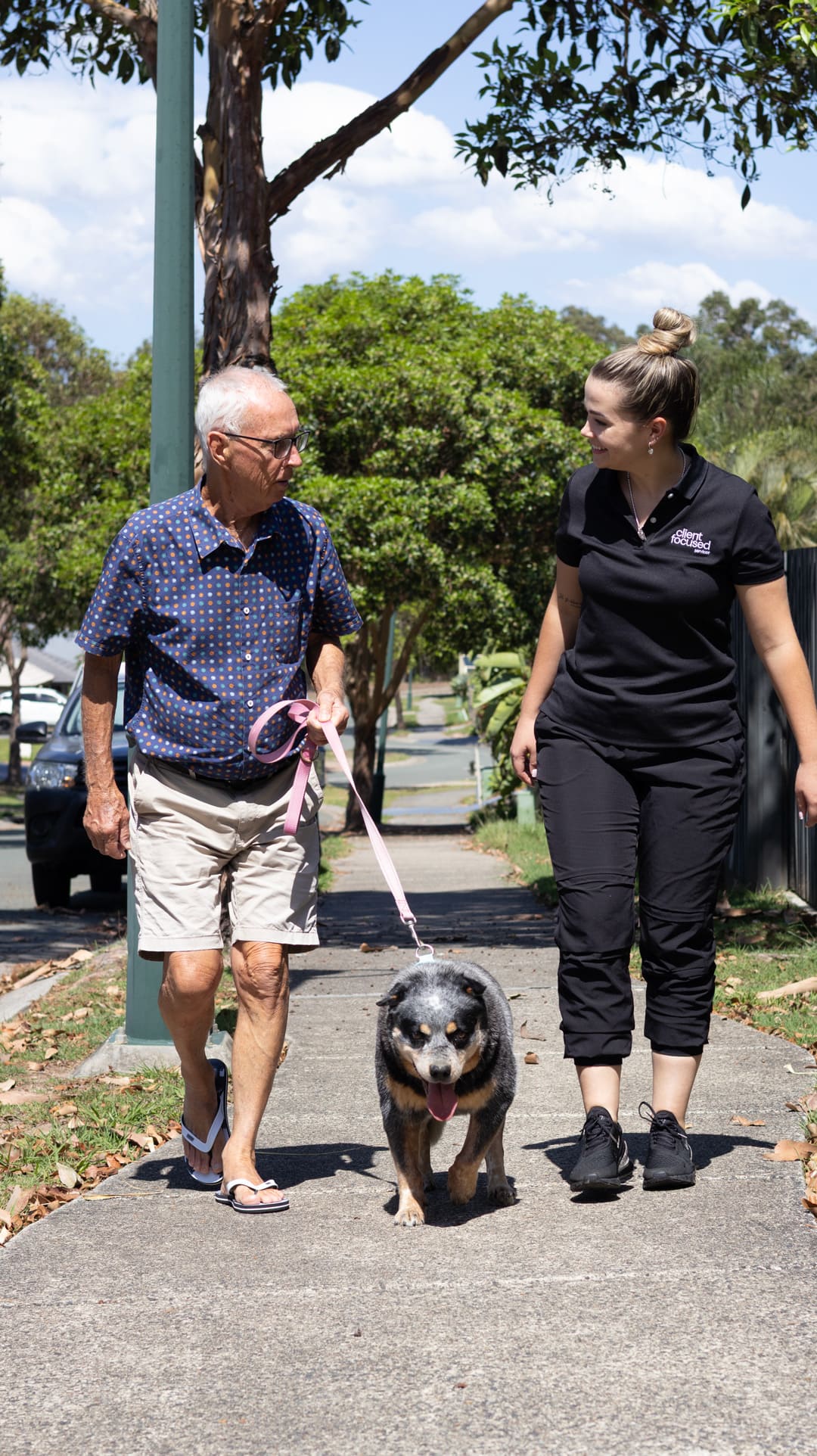 old man and woman walking with a dog